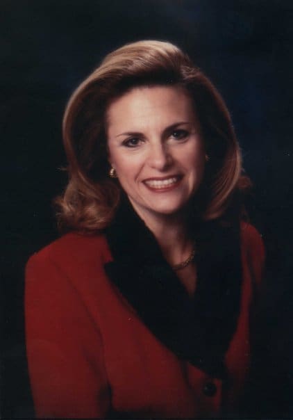 A woman in red jacket smiling for the camera.